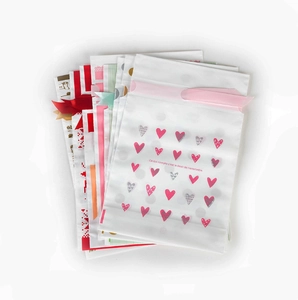 Detailed view of assorted decorative plastic gift bags with elegant ribbon drawstring closure