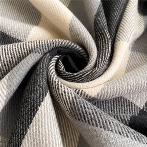 Macro shot of classic black and white plaid scarf showing soft wool texture and weave