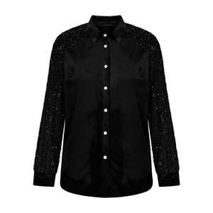 Detail of black velvet shirt with shiny sequin sleeves and smooth fabric texture