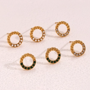 Detailed view of gold twisted hoop earrings with pearl, zircon, and emerald stones