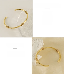 Macro detail of 18K gold plated C-shaped stainless steel bangle with twisted thread accents