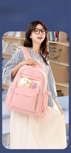 Pink college style nylon backpack with transparent window and decorative pom-poms