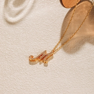Detailed close-up of 18K gold plated necklace featuring a zircon-encrusted M letter charm