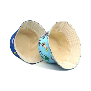 Kids reversible bucket hats with cartoon dinosaur and shark prints in blue and light blue