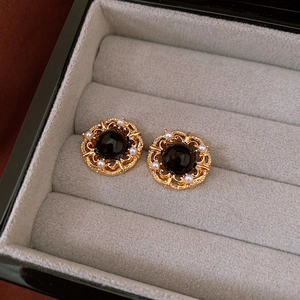 Close-up of vintage flower earrings with black crystal and pearls in a jewelry box
