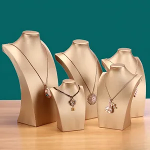 Golden PU leather necklace display busts in five sizes on green backdrop