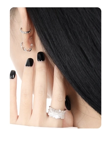 Close-up of minimalist irregular twisted silver studs and feather-textured ring set