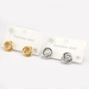 Pair of gold and silver twisted knot stainless steel earrings on a display card