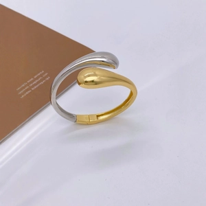 Minimalist teardrop open bangle in polished gold and silver tone metal finish