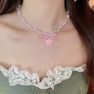 Close-up of pink beaded bow necklace with star pendant worn by model on neck