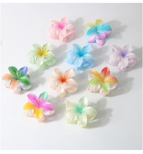 Detail of 10 gradient plumeria flower hair claws in various summer colors on white base
