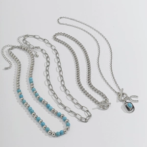 Detail of four-piece silver necklace set with turquoise beads and LUCKY horseshoe charm