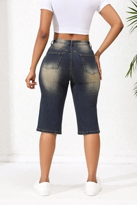 Rear view of women's washed dark blue denim bermuda shorts with worn-out texture