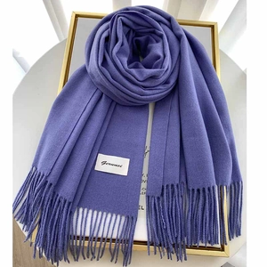 Detail of purple cashmere-like scarf with fringe ends and woven brand label