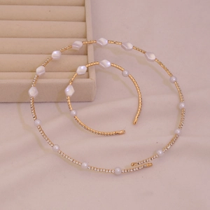 Elegant gold necklace and bracelet set with delicate white pearls and sparkling crystals