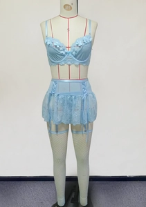 Détail de la lingerie en dentelle bleu clair avec motifs floraux et bas résilles