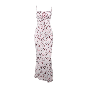Detalle del vestido veraniego blanco con flores rojas pequeñas y lazo en el escote