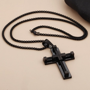 Polished black stainless steel cross pendant necklace with textured box chain on stone