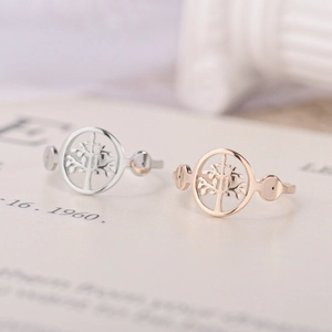 Macro shot of tree of life rings in silver and rose gold finishes on open book pages