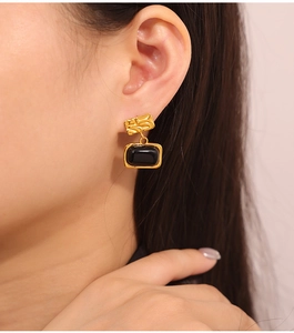 Close-up of vintage gold hammered texture earrings with black rectangular inlay on ear