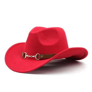 Detail of red wool felt cowboy hat with brown leather band and golden horsebit buckle