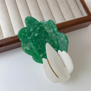 Detailed view of a unique cabbage-shaped acetate hair claw clip with green leaf textures