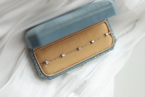Elegant silver starburst bracelet with five white gems in a blue velvet gift box