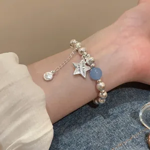 Star charm beaded stretch bracelet with brushed silver beads and a blue focal bead