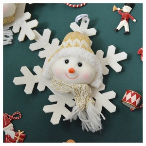 Detail of plush snowman hanging ornament with gold knit hat on large white snowflake