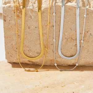 Detail of double-layered stainless steel snake chains with round beads in gold and silver