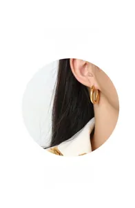 Close-up of polished golden C-shaped hoop earrings on a model showing smooth metallic finish