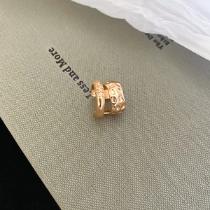 Close-up of gold double-layer ear cuff featuring one smooth and one textured metal ring