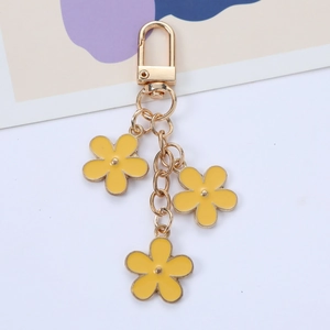 Golden keychain featuring three yellow enamel flower pendants with five petals each