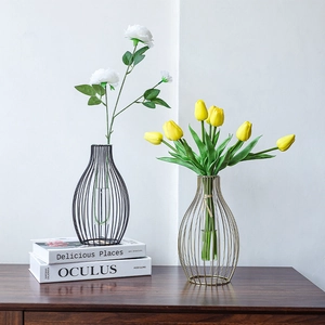 Modern gold and black lantern-style metal vases with glass tubes and faux flowers