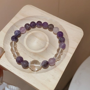 Detailed macro view of purple amethyst and clear quartz beads with silver floral spacers
