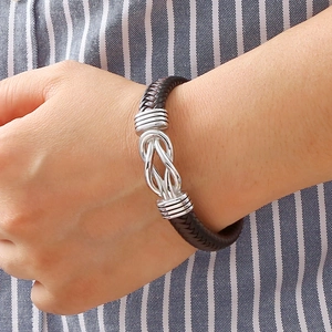 Classic dark brown braided leather bracelet with silver knot closure on a male model
