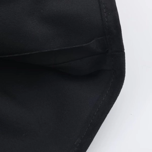 Gros plan détaillé sur la texture du daim noir et les coutures de précision sur la jupe courte