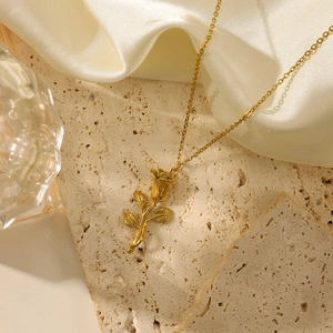 Elegant 18K gold plated rose flower pendant necklace displayed on premium stone and silk