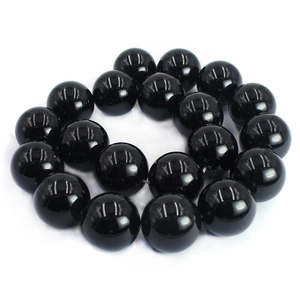 Macro shot of polished black agate round beads with glossy finish for jewelry making