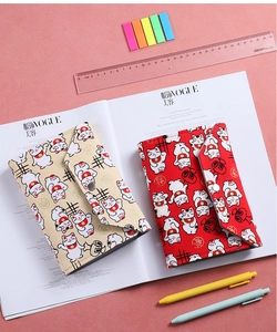 Detail of red and beige Maneki-neko budget binders with metal snap closure and gold foil motifs