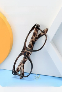 Vue détaillée d'une monture de lunettes ronde léopard pour enfants sur un support jaune