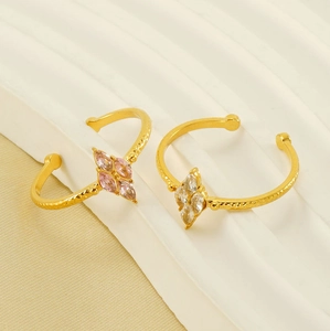 Detailed shot of gold open rings featuring pink and white marquise-cut zircon stones