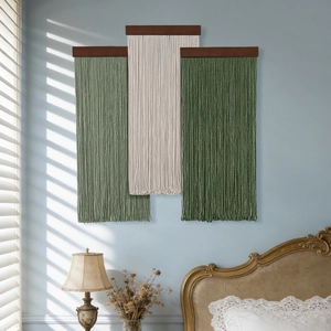 Three-piece set of woven tassel wall hangings in gradient green tones with wooden bars