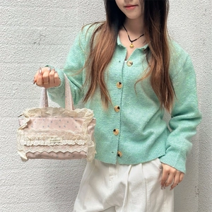 Détail d'un sac cabas en toile florale avec bordure en dentelle multicouche et zip