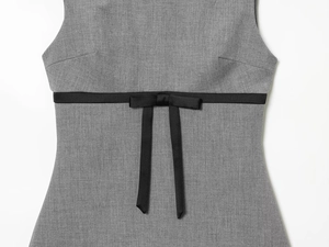Detailed view of grey sleeveless dress featuring a premium waist-accented black satin bow
