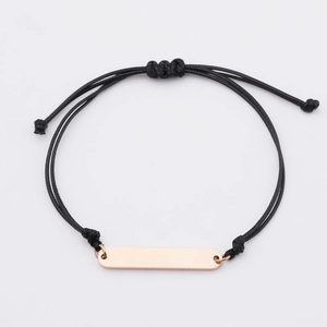 Minimalist woven black rope bracelet featuring a polished rose gold stainless steel bar