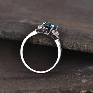 Detailweergave van zilveren ring met ovale groensteen en pavé gezette diamanten