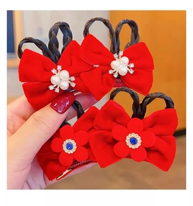 Close-up of red velvet bow hair clips with pearls, rhinestones and faux braided buns