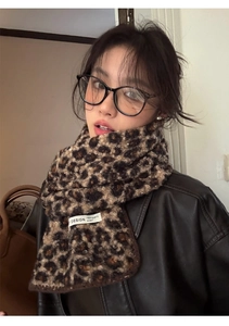 Detail showing the leopard print wool scarf with a high-quality brand logo fabric label