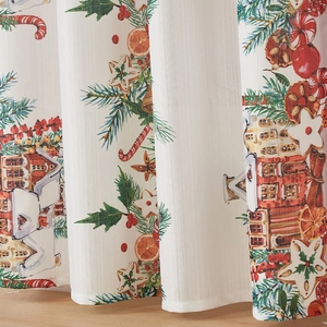 Detailed close-up of Christmas curtains with gingerbread house and candy cane patterns